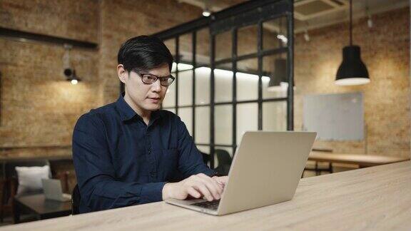 亚洲商人戴着眼镜在咖啡馆工作年轻英俊的男人在工作场所用电脑