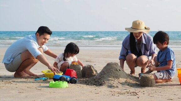 亚洲家庭快乐的玩在沙滩上堆起一堆沙子在夏天一起度假家庭旅行4k决议