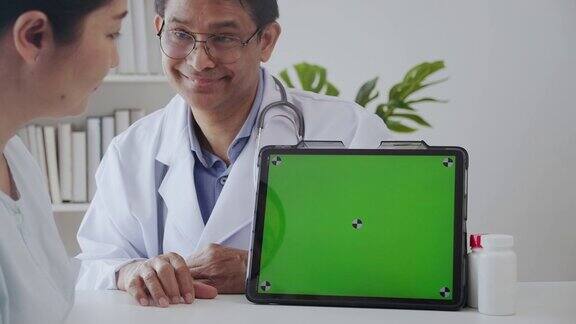 老医生微笑着用绿色屏幕向病人解释