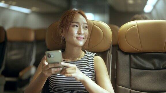 亚洲女性在飞机上使用智能手机