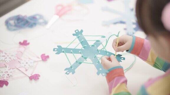 小女孩手工制作雪花工艺品供家庭教育使用