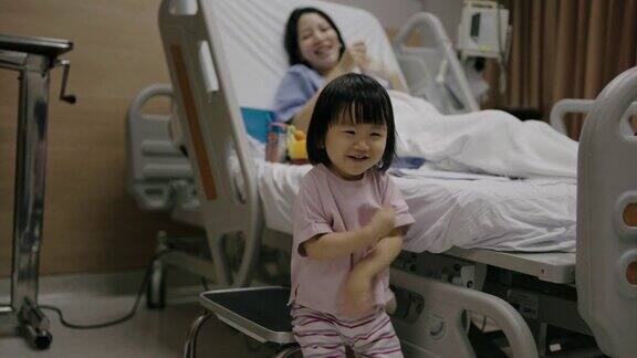 母亲在医院里看着女儿跳舞