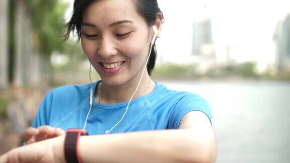 亚洲年轻运动女性使用智能手表健身跟踪