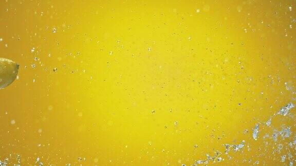 SLOMO柠檬被水喷在黄色背景上