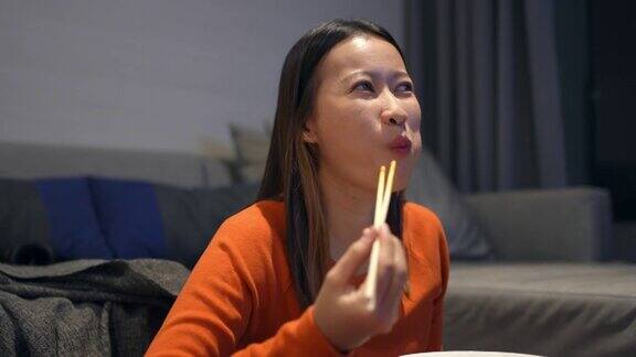 4K亚洲女人晚餐吃中国面条看电视电影