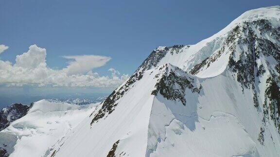 雄伟的高原全景雪山山峰高耸在阳光灿烂的天空与云彩