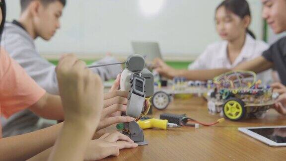 教育主题:聪明的学校男孩建立一个小机器人手臂和使用笔记本电脑编程软件的机器人工程类作为学校科学项目科学与人的观念