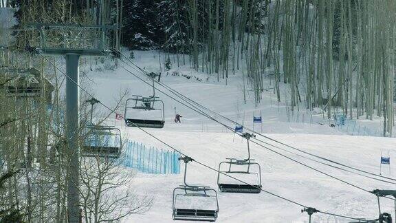 在冬季的科罗拉多山滑雪场(比弗溪)人们在斜坡上滑雪而滑雪缆车在前景中运行