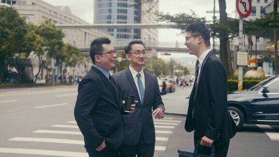 三个亚洲商人在街角碰面交谈