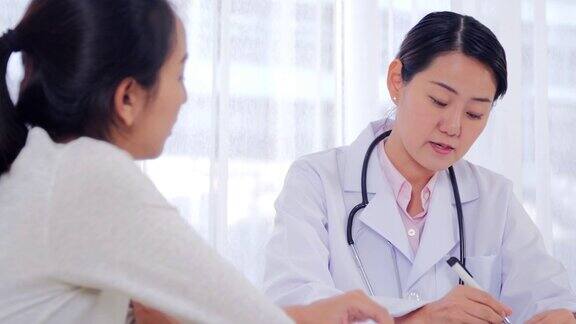 医疗咨询:年轻的女医生在医生的办公室里咨询病人她正在接受处方药物医生咨询女患者