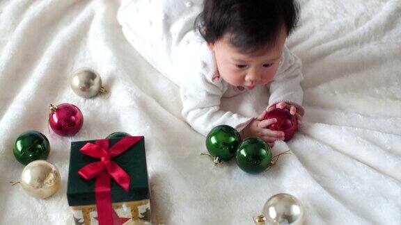 亚洲小女孩玩圣诞装饰品和礼物盒