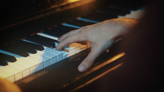 钢琴家的手在金色模糊的背景上弹钢琴