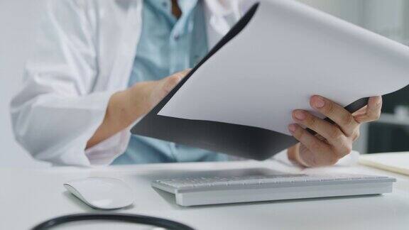 近距离的成熟亚洲男子医生使用笔记本电脑视频通话医疗结果在咨询病人在健康诊所