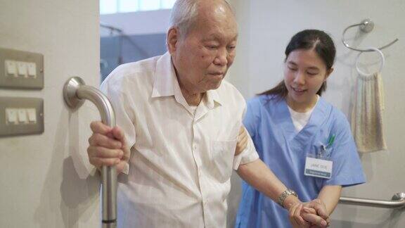 老年男子与护工在卫生间使用安全滑扶手