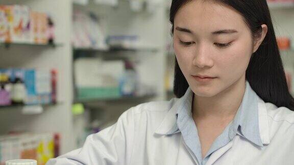 年轻的亚洲女药剂师数处方药丸药物