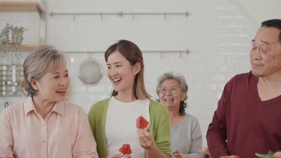 快乐的亚洲老年人在素食烹饪上的联系:厨房里的爱、笑声和团聚