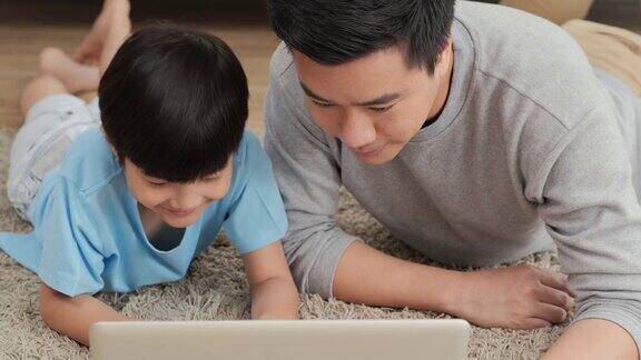 父子在家里一起使用电脑心情愉快家庭、科技和生活理念