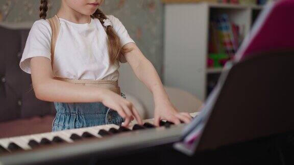 女孩一边弹钢琴一边皱着眉头专心地看着乐谱
