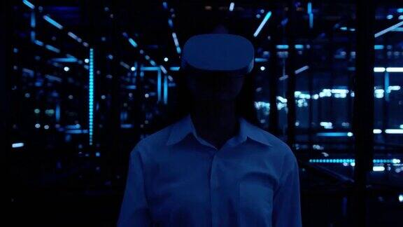 亚洲少女戴着虚拟现实头盔在黑暗的夜晚在五颜六色的紫外线灯光下体验虚拟现实并在触摸