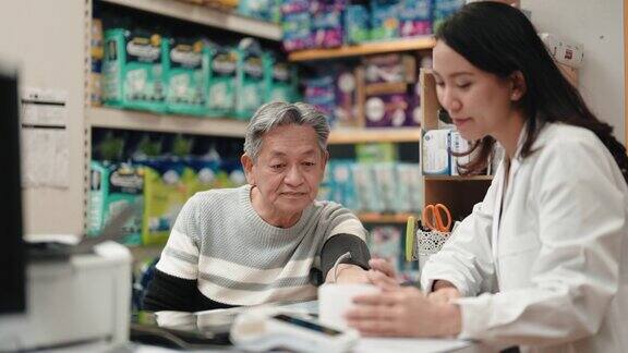 亚洲华人女药剂师与男子在药店测量血压