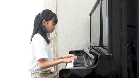 弹奏立式钢琴的日本女孩