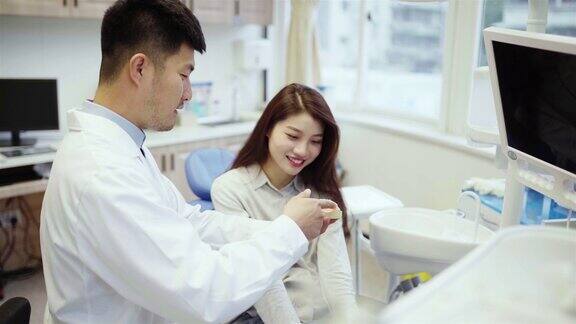 正牙医生在诊所向病人解释植入物