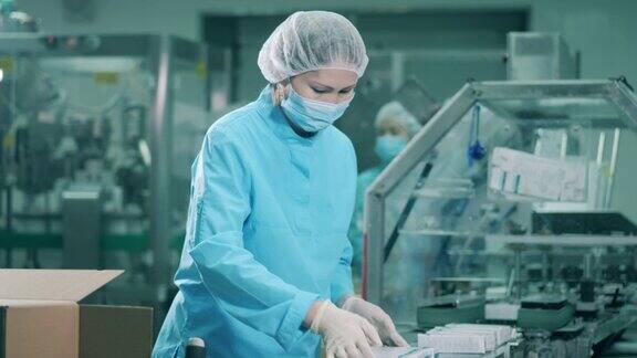 亚裔女性药剂师把药品装进盒子里制药厂生产线