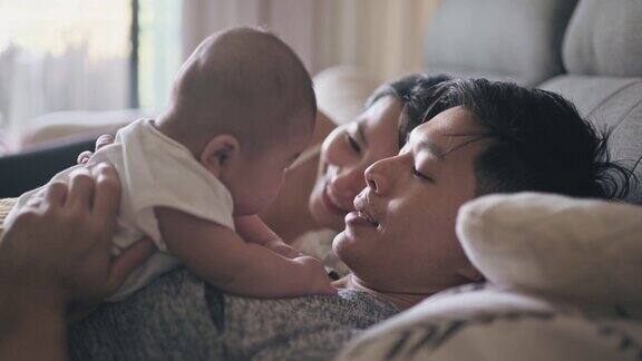 亚裔中国父母周末早上躺在床上和他们的孩子亲密无间