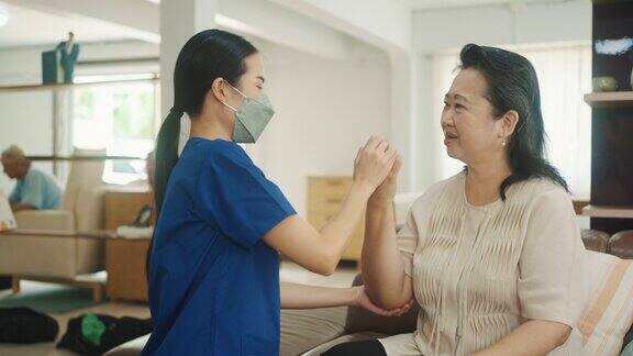 亚洲高级妇女做物理治疗师在家里的治疗师医生的支持