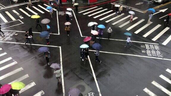 行人在雨中过街人们拿着雨伞鸟瞰