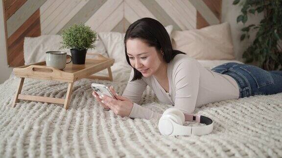 年轻的亚洲女性使用智能手机浏览社交媒体查看新闻玩手机游戏或发短信