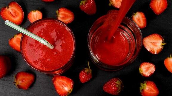 新鲜的草莓冰沙在玻璃杯中流动准备饮用