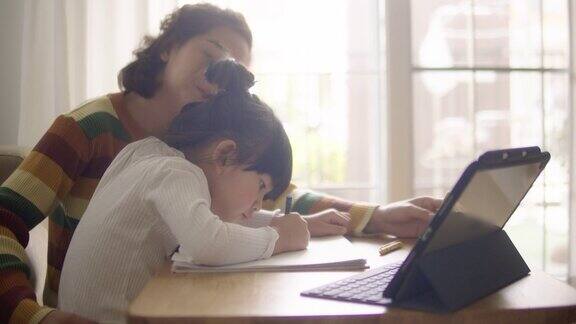 亚裔女儿在家和母亲一起参加网络课程