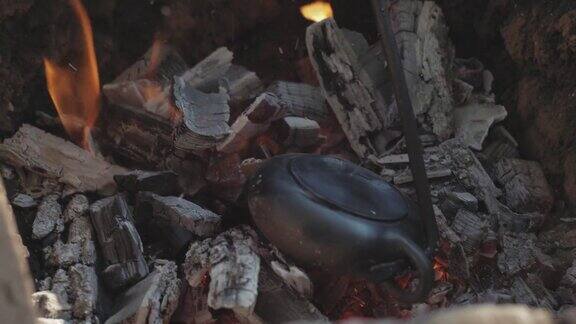 宜兴茶煲在火上烧制在篝火上烧一个泥茶壶茶道用手工陶壶4k的视频59.94帧秒