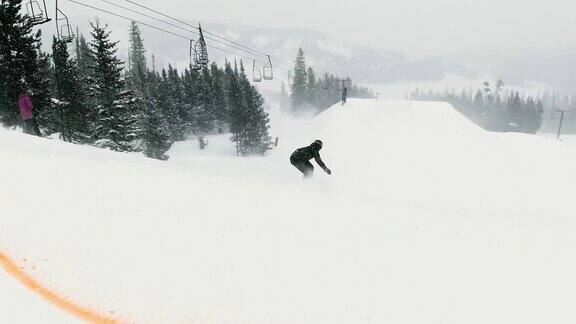 完成一个“开关540尾巴抓斗”在一个跳跃与森林和滑雪跳跃的背景在埃尔多拉滑雪度假村附近的博尔德科罗拉多州在一个下雪的阴天的诡计