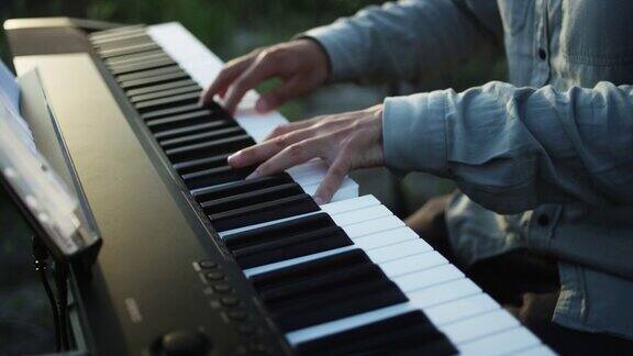 弹奏数码钢琴的特写侧视图双手按下钢琴琴键钢琴学习课程