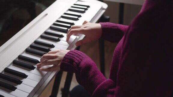 年轻女子在网上用在家视频教程上钢琴课
