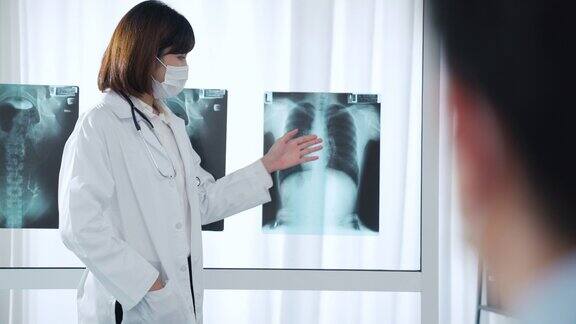 女医生在医务室向病人解释x光片的结果