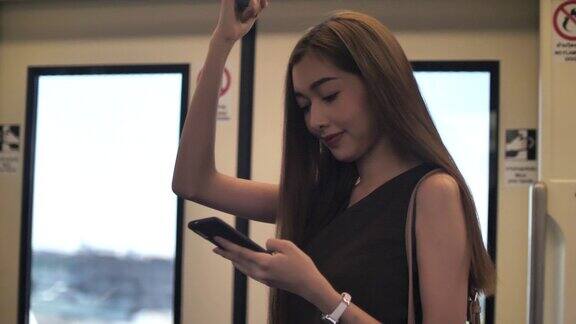 亚洲女性在地铁里使用手机