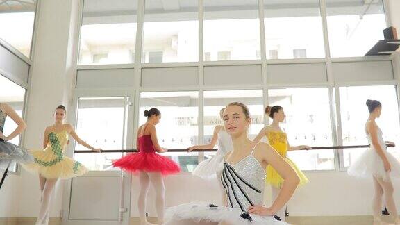 美丽的芭蕾舞女演员坐在地板上