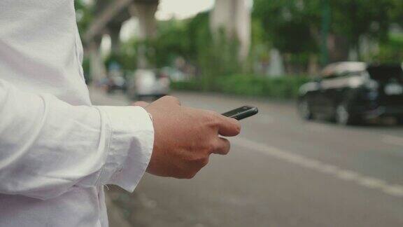 一个年轻人在城市里用他的智能手机