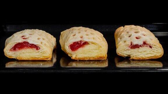 时间流逝-三个自制的面包和红色草莓酱在电烤箱烤