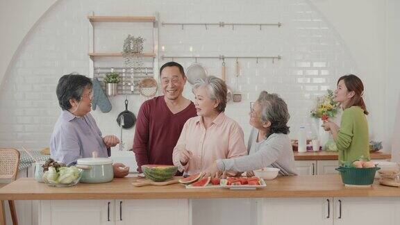 快乐的亚洲老年人在素食烹饪上的联系:厨房里的爱、笑声和团聚