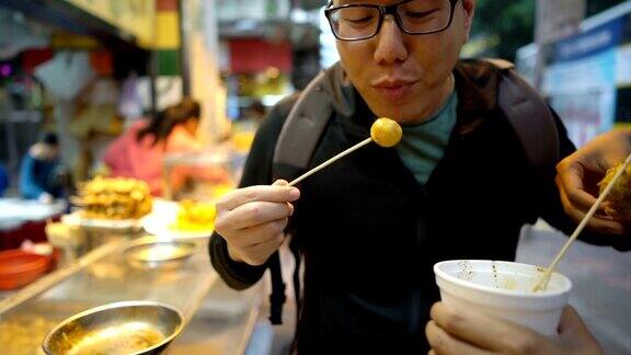 和朋友在香港街头吃鱼丸