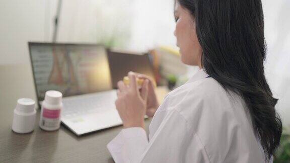 亚洲女医生vdo在诊所用笔记本电脑与病人通话白大褂医生在医院办公室谈论健康问题和诊断
