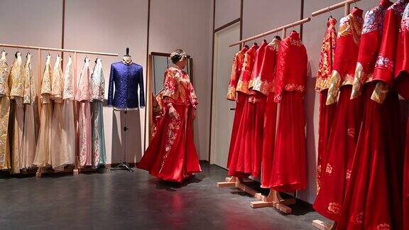 年轻的中国新娘在设计师工作室试穿婚纱