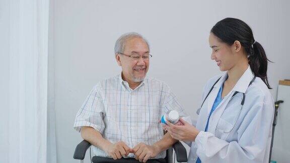 亚洲老年男性患者在敬老院与医生护士会诊护理治疗师药剂师女孩拿着药瓶在家里的客厅里给老人解释处方