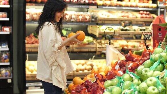 亚洲女人的手在超市里拿着蔬菜