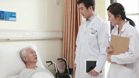 年轻的亚洲医生交谈和安慰老病人