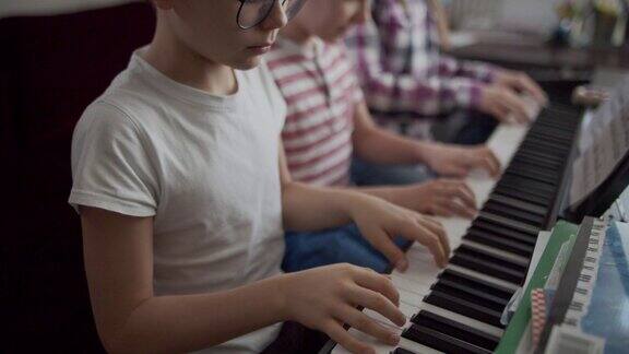 三个孩子一起玩电子钢琴